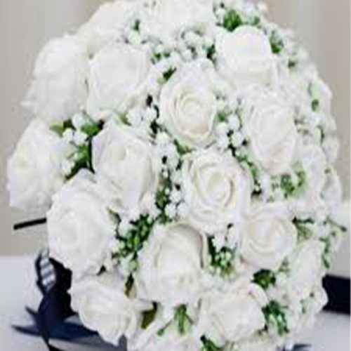 Elegant white bridal bouquet featuring fresh roses and wedding flowers arranged with green accents by Purple Orchid Florist Select 82 more words to run Humanizer.